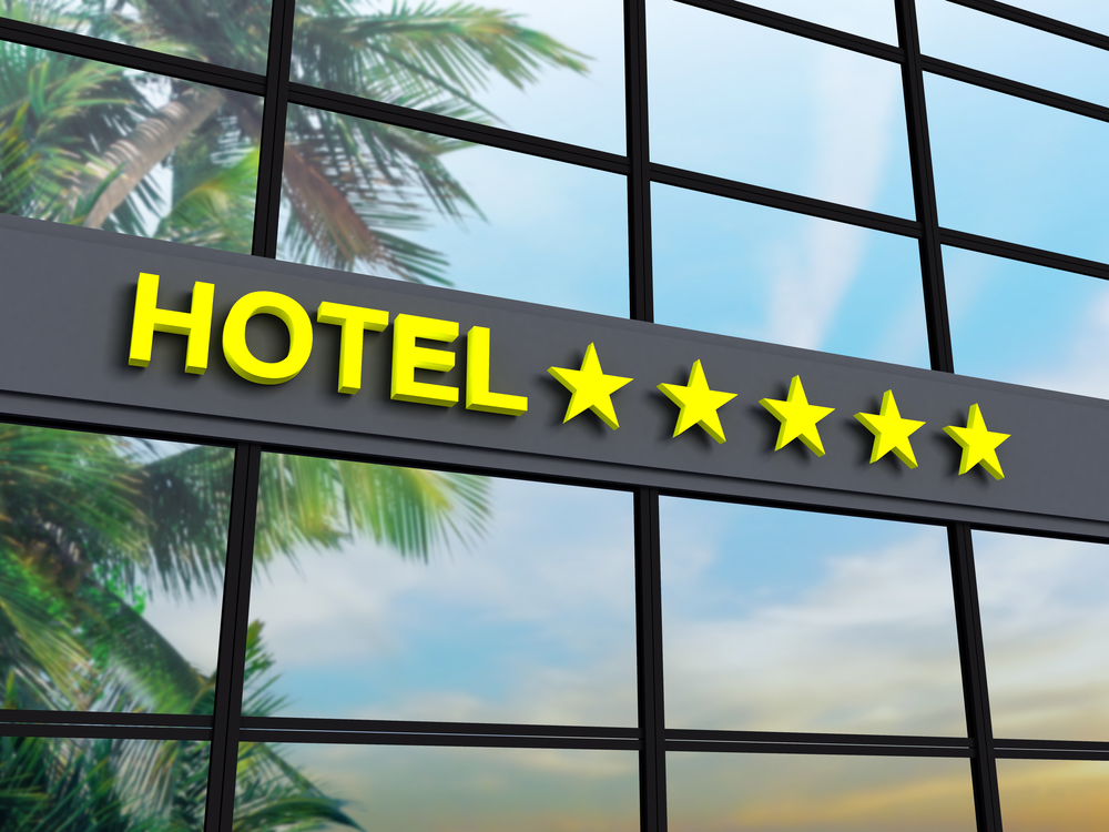 Detail of a five stars hotel with reflecting sky and palm trees